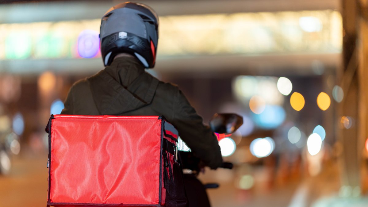 Couriers navigate busy streets for quick deliveries. (Shutter Stock Photo)