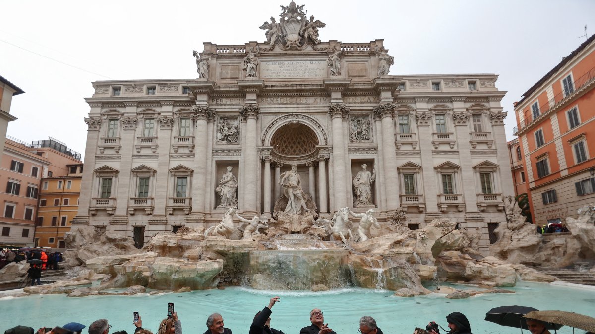 Rome&#039;s Mayor Roberto Gualtieri tosses a coin into the Trevi Fountain as it reopens to the public after maintenance work, Rome, Italy, Dec. 22, 2024. (Reuters Photo)