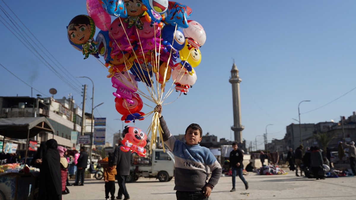 A child holds a bunch of balloons in the town square as life returns to normal after the Syrian National Army (SNA) liberated Manbij from PKK/YPG occupation, Manbij, Syria, Dec. 23, 2024. (AA Photo)