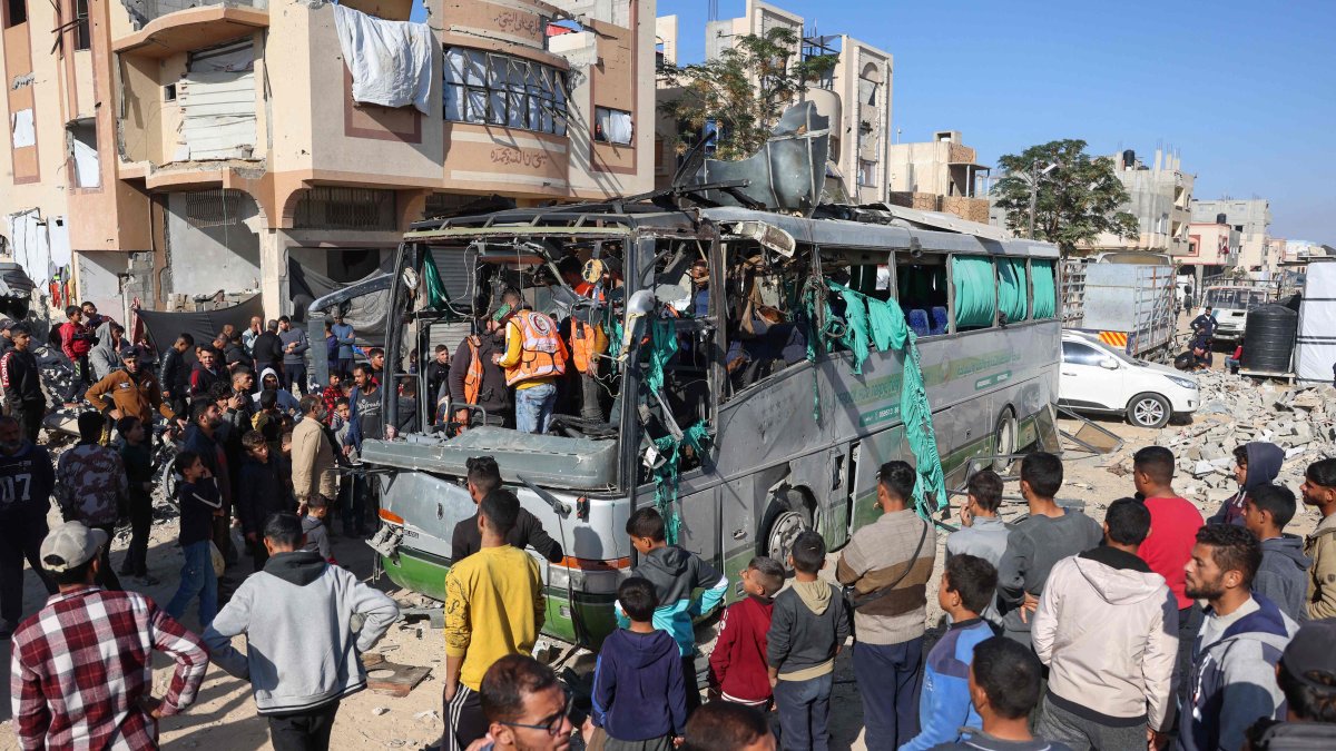 People and rescuers inspect the carcass of a bus hit by an Israeli strike which led to casualties, in the Mawasi area west of Khan Younis city in the southern Gaza Strip, Dec. 23, 2024. (AFP Photo)