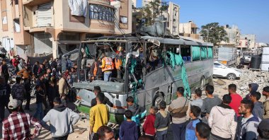 People and rescuers inspect the carcass of a bus hit by an Israeli strike which led to casualties, in the Mawasi area west of Khan Younis city in the southern Gaza Strip, Dec. 23, 2024. (AFP Photo)