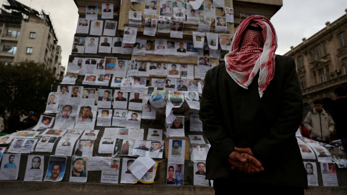 A man looks at the pictures of missing people, believed to be held in Sednaya prison, known as a &quot;slaughterhouse&quot; under Syria&#039;s Bashar Assad&#039;s rule, in Marjeh Square, Damascus, Syria Dec. 22, 2024. (Reuters Photo)