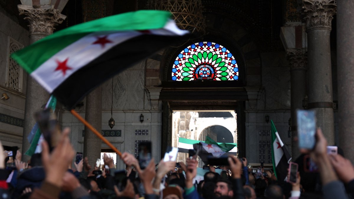 Syrians wave the new Syrian flag after Friday Noon prayers at the Umayyad Mosque in the capital Damascus, Syria, Dec. 20, 2024. (AFP Photo)