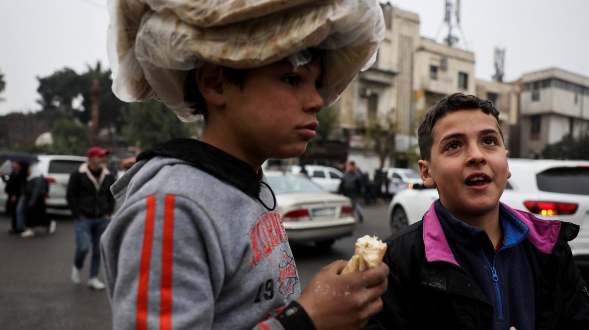 Children carry bread on a street, after the ousting of Syria&#039;s Bashar Assad, in Damascus, Syria, Dec. 24, 2024. (Reuters Photo)