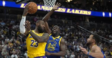 Los Angeles Lakers forward LeBron James (L) passes around Golden State Warriors' Draymond Green during the first half of an NBA preseason basketball game, Las Vegas, U.S., Oct. 15, 2024. (AP Photo)