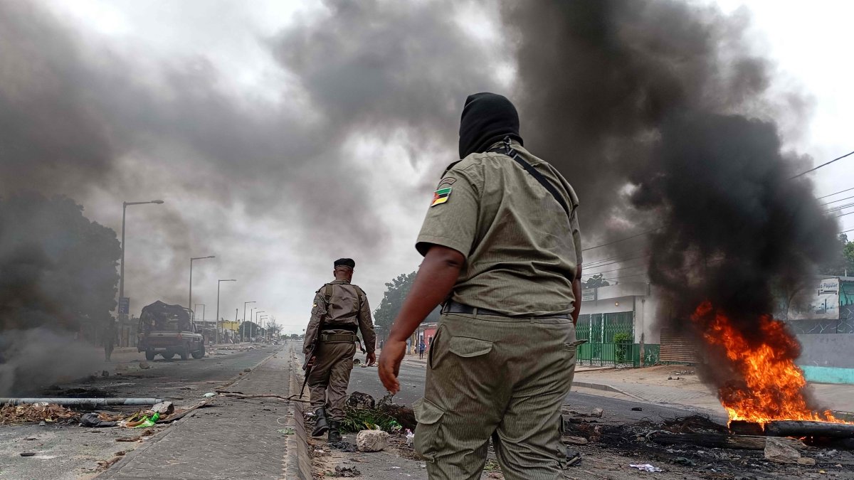 Mozambican security forces are seen next to a burning barricade amid demonstrations, Maputo, Mozambique, Dec. 24, 2024. (AFP Photo)