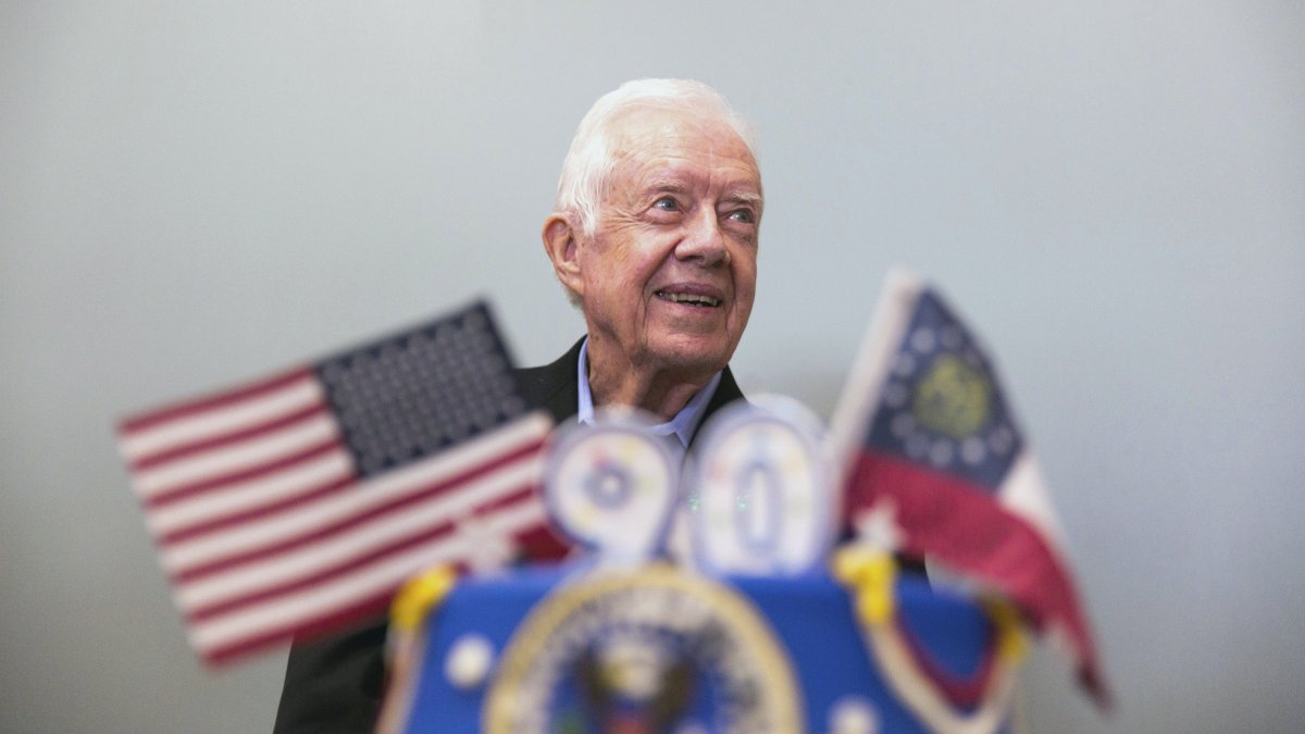 Former President Jimmy Carter stands behind his birthday cake during his 90th birthday celebration held at Georgia Southwestern University, in Americus, Georgia, U.S., Oct. 4, 2014. (AP Photo)