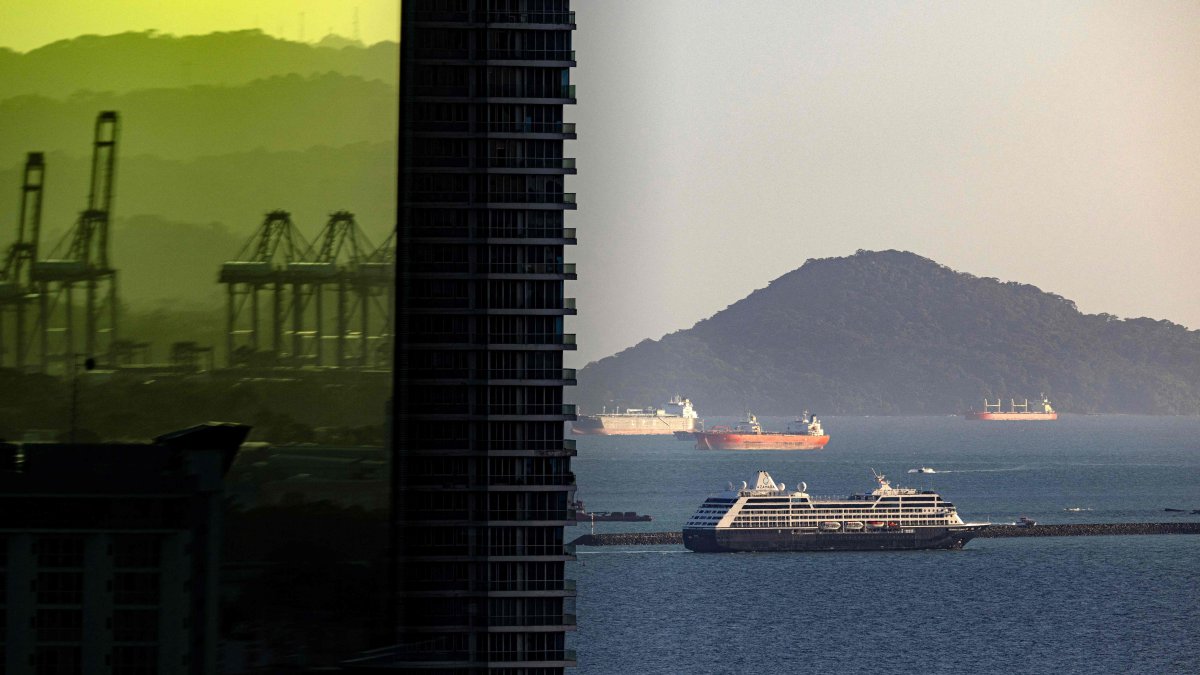 Port cranes are seen reflected on a building as a cruise ship sails through the Pacific side exit of the Panama Canal, Panama City, Panama, Dec. 12, 2024. (AFP Photo)