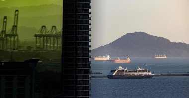 Port cranes are seen reflected on a building as a cruise ship sails through the Pacific side exit of the Panama Canal, Panama City, Panama, Dec. 12, 2024. (AFP Photo)