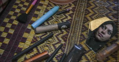 Alaa Hamami gazes into a fragment of a broken mirror as she poses for a photo at a tent camp for displaced Palestinians in Deir al-Balah, Gaza Strip, Palestine, Dec. 18, 2024. (AP Photo)