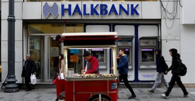 A street vendor sells roasted chestnuts in front of a branch of Halkbank, Istanbul, Türkiye, Jan. 10, 2018. (Reuters Photo)