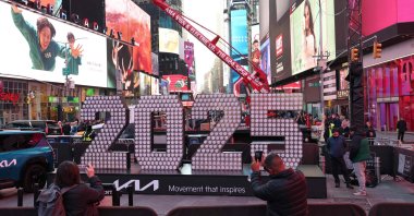 People take photos with the 2025 New Year’s Eve sign in Times Square, New York City, U.S., Dec. 18, 2024. (AFP Photo)
