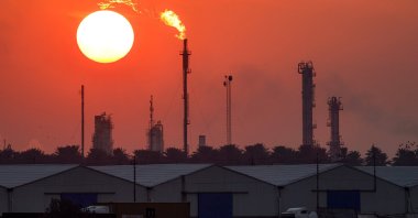 The sun sets behind burning gas flares at the Dora (Daura) Oil Refinery Complex, Baghdad, Iraq, Dec. 22, 2024. (AFP Photo)