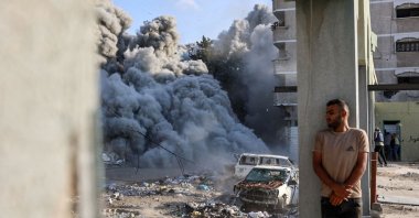 A man takes cover behind a column as an explosion during an Israeli strike in the Zeitoun district, Gaza City, Sept. 1, 2024. (AFP Photo)
