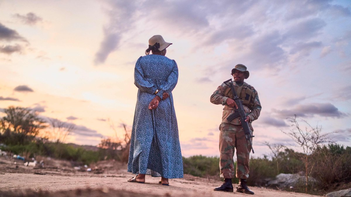 A member of the South Africa National Defence Forces (SANDF) speaks with a pregnant woman he apprehended while she used an illegal route into South Africa, near Musina, Zimbabwe, Nov. 28, 2024. (AFP Photo)