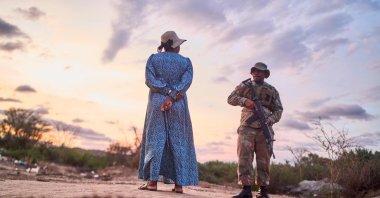 A member of the South Africa National Defence Forces (SANDF) speaks with a pregnant woman he apprehended while she used an illegal route into South Africa, near Musina, Zimbabwe, Nov. 28, 2024. (AFP Photo)