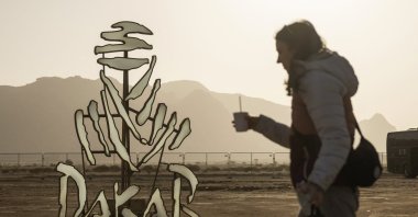 A woman walks past a Dakar Rally logo installation ahead of the Dakar Rally, Bisha, Saudi Arabia, Jan. 2, 2025. (Reuters Photo)