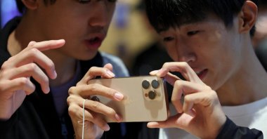 People check an iPhone 16 Pro as the new iPhone 16 series smartphones go on sale at an Apple store in Beijing, China, Sept. 20, 2024. (Reuters Photo)