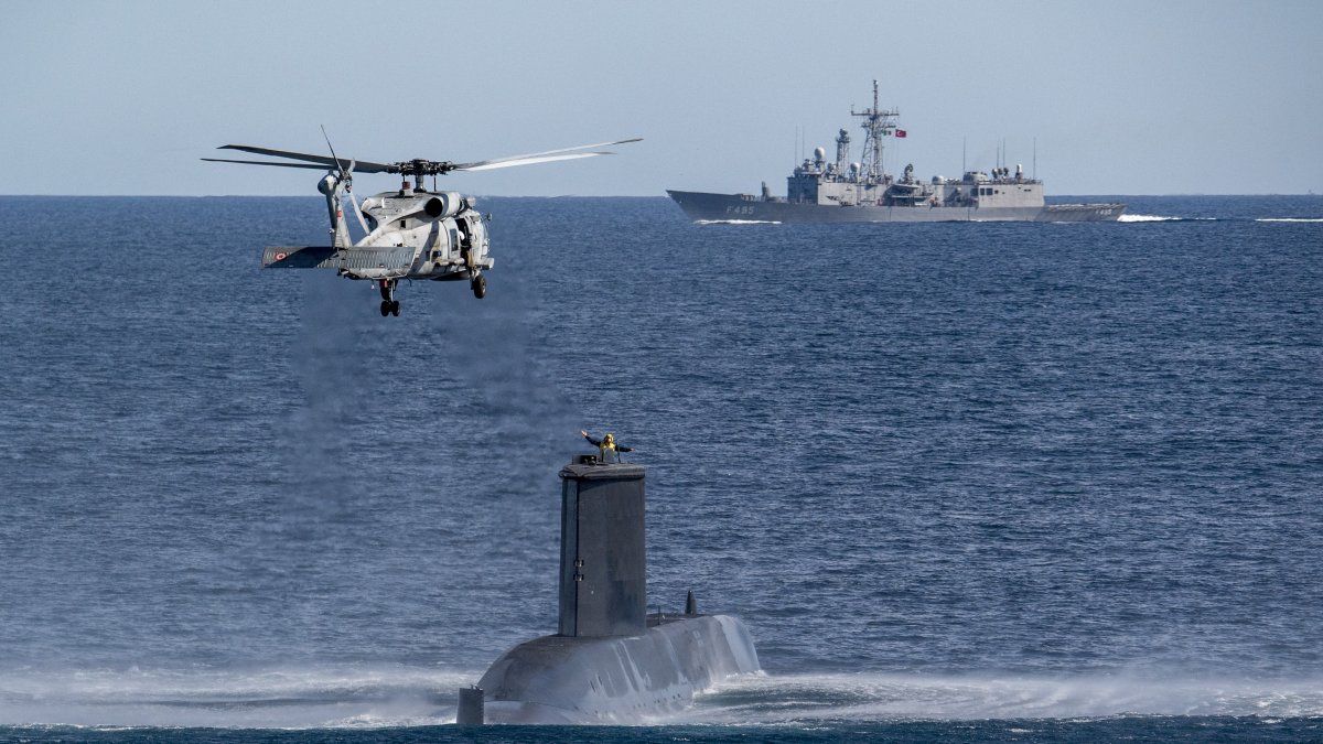 A Turkish navy helicopter, ship and submarine take part in a warfare exercise off the coast of Catania, Sicily, Italy, Feb. 26, 2024. (AP Photo) 