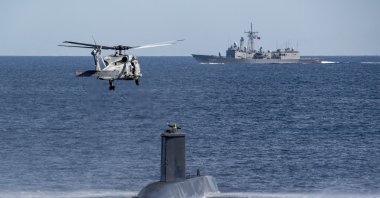 A Turkish navy helicopter, ship and submarine take part in a warfare exercise off the coast of Catania, Sicily, Italy, Feb. 26, 2024. (AP Photo) 