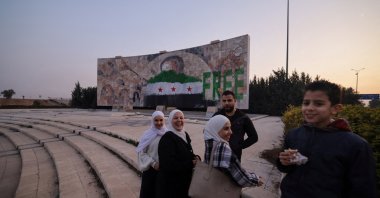 People stand near graffiti of the Syrian flag painted on a mosaic of former Syrian regime leader Hafez Assad after the ousting of Bashar Assad, Damascus, Syria, Jan. 2, 2025. (Reuters Photo)