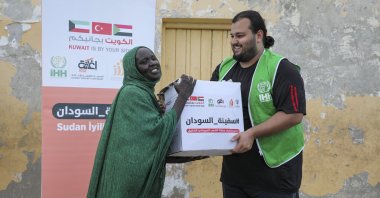 A Humanitarian Relief Foundation (IHH) team member delivers essential aid to a woman in Sudan, Oct. 31, 2024.  (AA Photo)