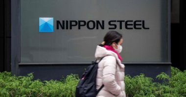 A woman walks past the logo of Japan&#039;s largest steel manufacturer, Nippon Steel, displayed in front of the company&#039;s head office in Tokyo, Japan, Jan. 6, 2025. (AFP Photo)