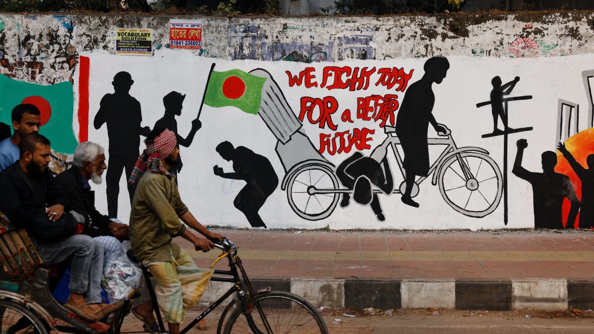 Commuters on a rickshaw pass by graffiti illustrating the Student Movement of 2024, Dhaka, Bangladesh, Jan. 1, 2025. (Reuters Photo)