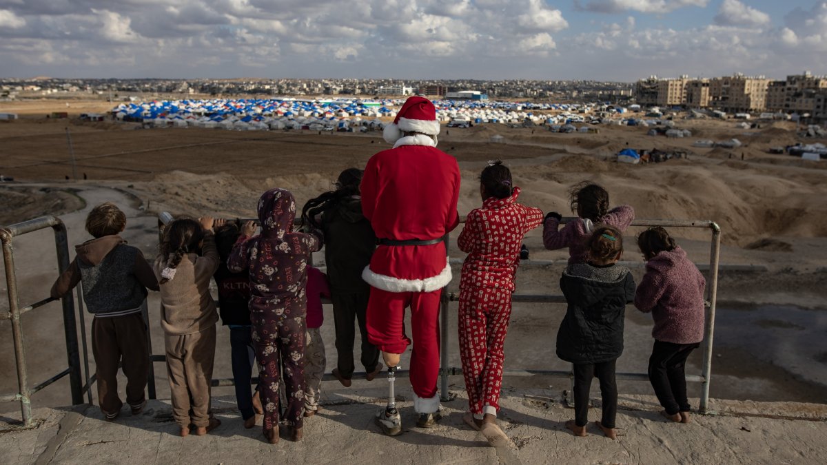 Omar Abu Hashem (L), a 26-year-old displaced Palestinian from Khan Younis, who lost a leg during the Israeli invasion of the Gaza Strip, plays with children dressed as Santa Claus as he visits destroyed homes and temporary tent shelters of displaced families in Khan Younis, Gaza Strip, Palestine, Jan. 5, 2025. (EPA Photo)