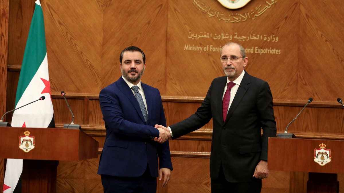 Syrian Foreign Minister Asaad al-Shaibani and Jordanian Foreign Minister Ayman Safadi shake hands during a press conference in Amman, Jordan, Jan. 7, 2025. (Reuters Photo)