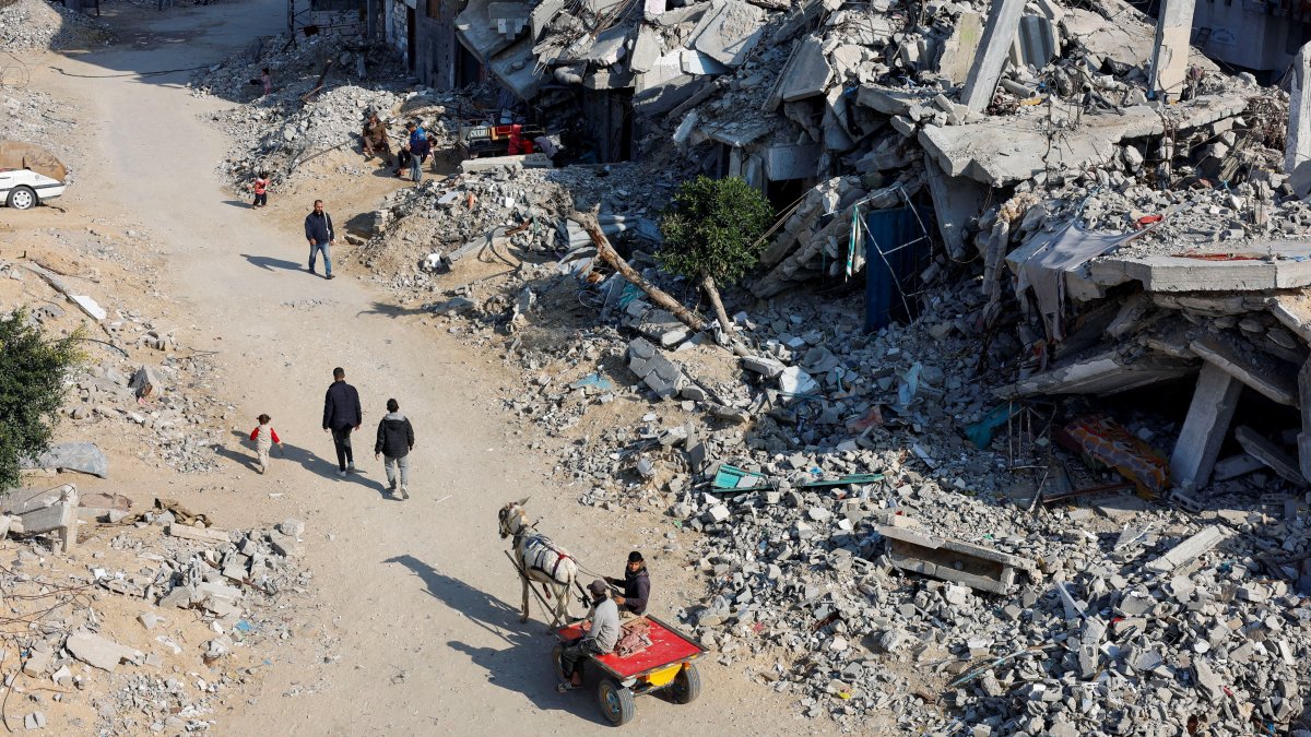 Palestinians ride a donkey-drawn cart as others walk past the rubble of houses destroyed in Israeli attacks, Khan Younis, southern Gaza Strip, Palestine, Jan. 7, 2025. (Reuters Photo)