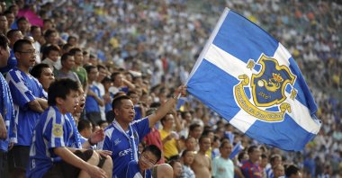 Chinese fans from the Guangzhou F.C. Fans Union cheer during a match for the Super League of Chinese Football Association in Guangzhou, Guangdong, China, Aug. 8, 2009. (AP Photo)