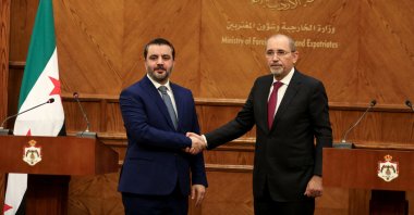 Syrian Foreign Minister Asaad al-Shaibani and Jordanian Foreign Minister Ayman Safadi shake hands during a press conference in Amman, Jordan, Jan. 7, 2025. (Reuters Photo)