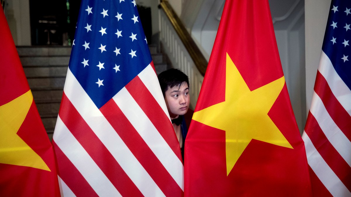 A worker helps arrange U.S. and Vietnamese flags before then-U.S. Secretary of State Mike Pompeo and then-Vietnamese Foreign Minister Pham Binh Minh arrive for a meeting, Hanoi, Vietnam, Feb. 26, 2019. (Reuters Photo)