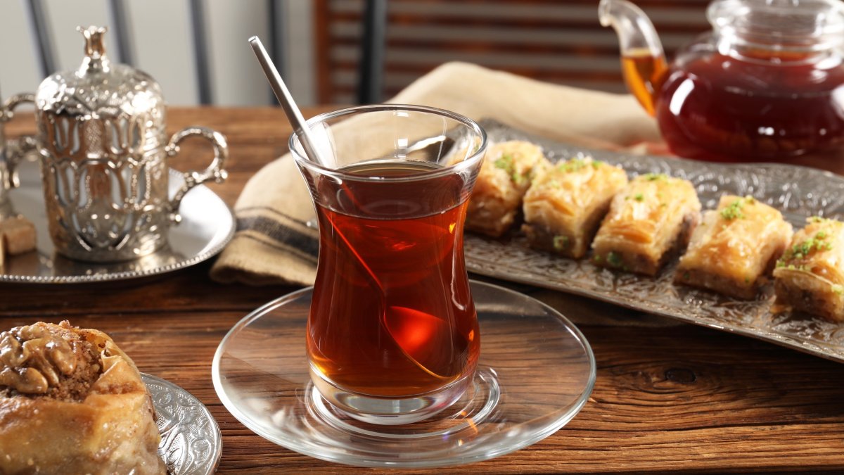 Turkish tea and sweets are served in a vintage tea set on a wooden table. (Shutterstock)