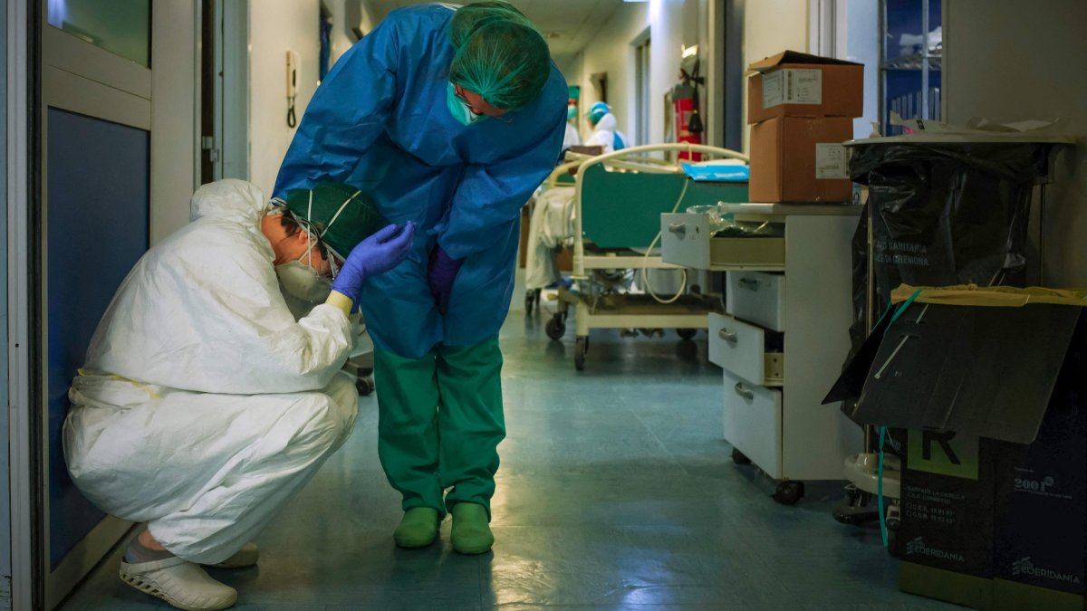 A nurse wearing a protective mask and gear comforts another as they change shifts, Milan, Italy, March 13, 2020. (AFP Photo)