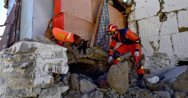 A rescuer searches a house for survivors with a rescue dog after an earthquake at Cuoguo township in Tibet&#039;s Shigatse, southwestern China, Jan. 8, 2025. (AFP Photo)