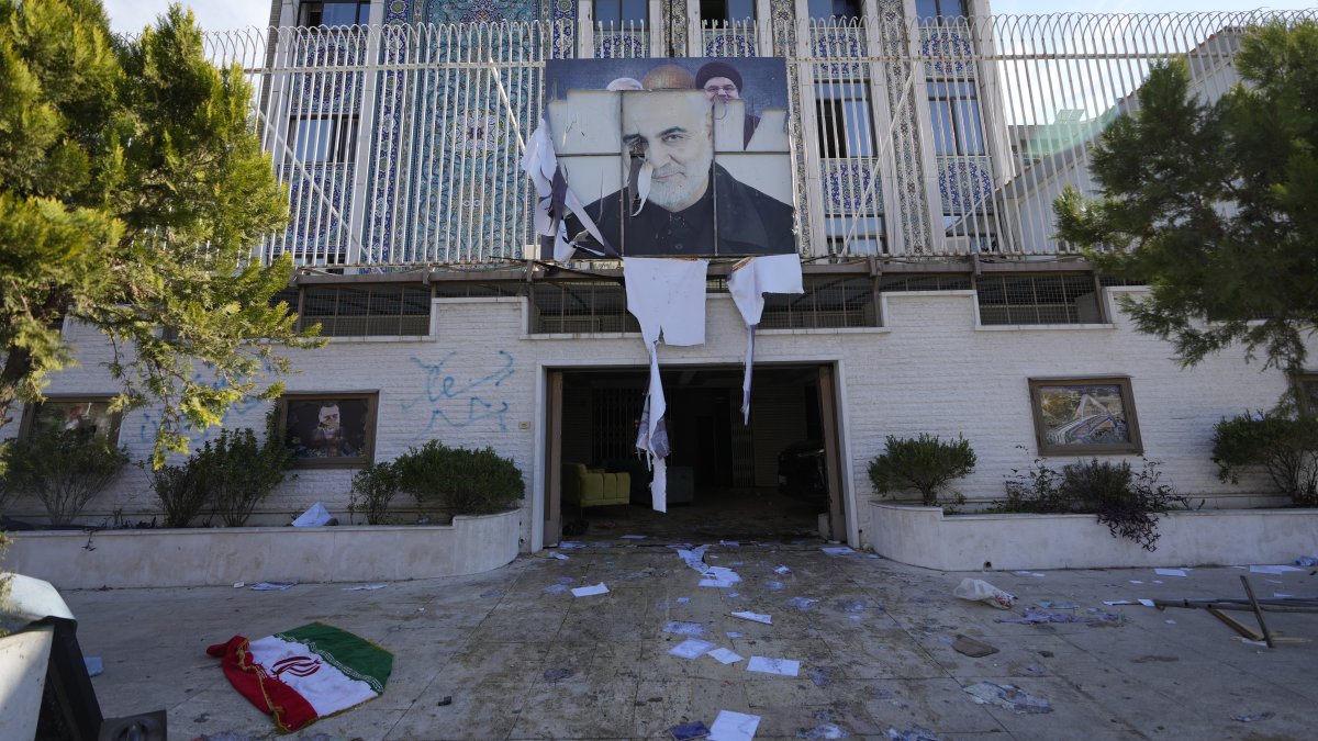 An Iranian flag lies on the ground at the entrance of the Iranian embassy which damaged by opposition fighters in Damascus, Syria, Sunday, Dec. 8, 2024. (AP Photo/Hussein Malla)