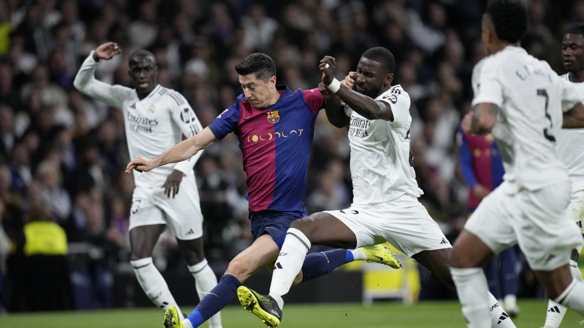 Barcelona&#039;s Robert Lewandowski (2nd L) fights for the ball against Real Madrid&#039;s Antonio Rudiger during a Spanish La Liga match at the Santiago Bernabeu stadium, Madrid, Spain, Oct. 26, 2024. (AP Photo)