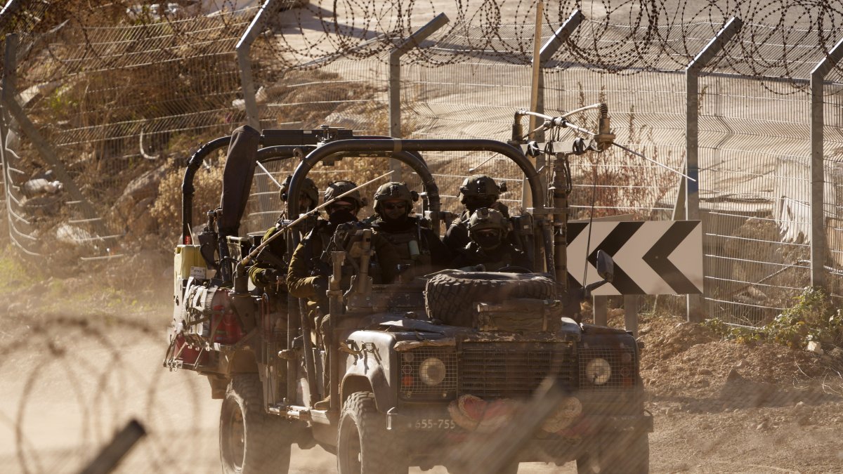 Israeli soldiers drive an armored vehicle along the security fence near the Alpha Line that separates the Israeli-controlled Golan Heights from Syria, Majdal Shams, Dec. 19, 2024. (AP Photo)