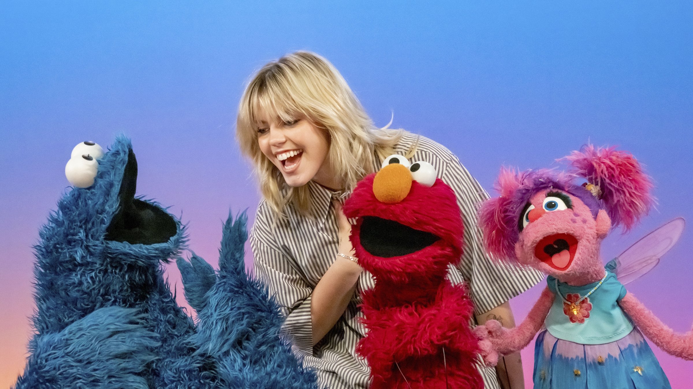 This image released by Sesame Workshop shows actor-singer Renee Rapp with muppet characters Cookie Monster, from left, Elmo and Abby Cadabby on the set of &quot;Sesame Street.&quot; (AP Photo)