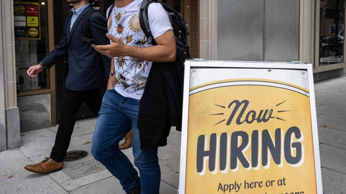 People walk past a restaurant with a hiring sign outside in Washington, D.C., U.S., Oct. 5, 2023. (AFP Photo)