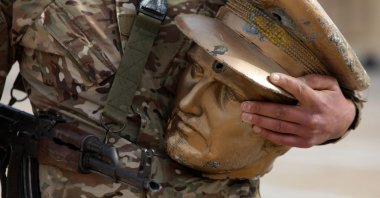 A fighter affiliated with Syria's new administration carries the head of a toppled equestrian statue of Bassel Assad, the eldest son of late Syrian regime head Hafez Assad, Damascus, Syria, Jan. 4, 2025. (AFP Photo)