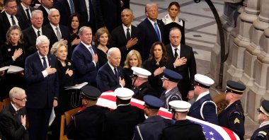 U.S. Military Body Bearers carry the flag-draped casket bearing the remains of former U.S. President Jimmy Carter from the Washington National Cathedral following his state funeral as (L-R) Jack Carter, Former U.S. Vice Presidents Al Gore and Mike Pence, Karen Pence, former U.S. President Bill Clinton, former Secretary of State Hillary Clinton, former U.S. President George W. Bush, Laura Bush, former U.S. President Barack Obama, U.S. President-elect Donald Trump, Melania Trump, U.S. President Joe Biden, first lady Jill Biden U.S. Vice President Kamala Harris and second gentleman Doug Emhoff look on, Washington, U.S., Jan. 9, 2025. (AFP Photo)
