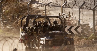 Israeli soldiers drive an armored vehicle along the security fence near the Alpha Line that separates the Israeli-controlled Golan Heights from Syria, Majdal Shams, Dec. 19, 2024. (AP Photo)