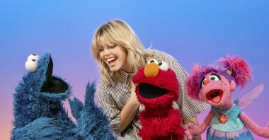 This image released by Sesame Workshop shows actor-singer Renee Rapp with muppet characters Cookie Monster, from left, Elmo and Abby Cadabby on the set of &quot;Sesame Street.&quot; (AP Photo)