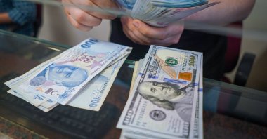 A man at an exchange office counts Turkish lira banknotes in Ankara, Türkiye, June 13, 2022. (Reuters Photo)