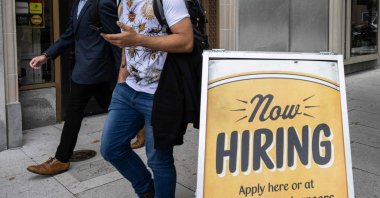 People walk past a restaurant with a hiring sign outside in Washington, D.C., U.S., Oct. 5, 2023. (AFP Photo)