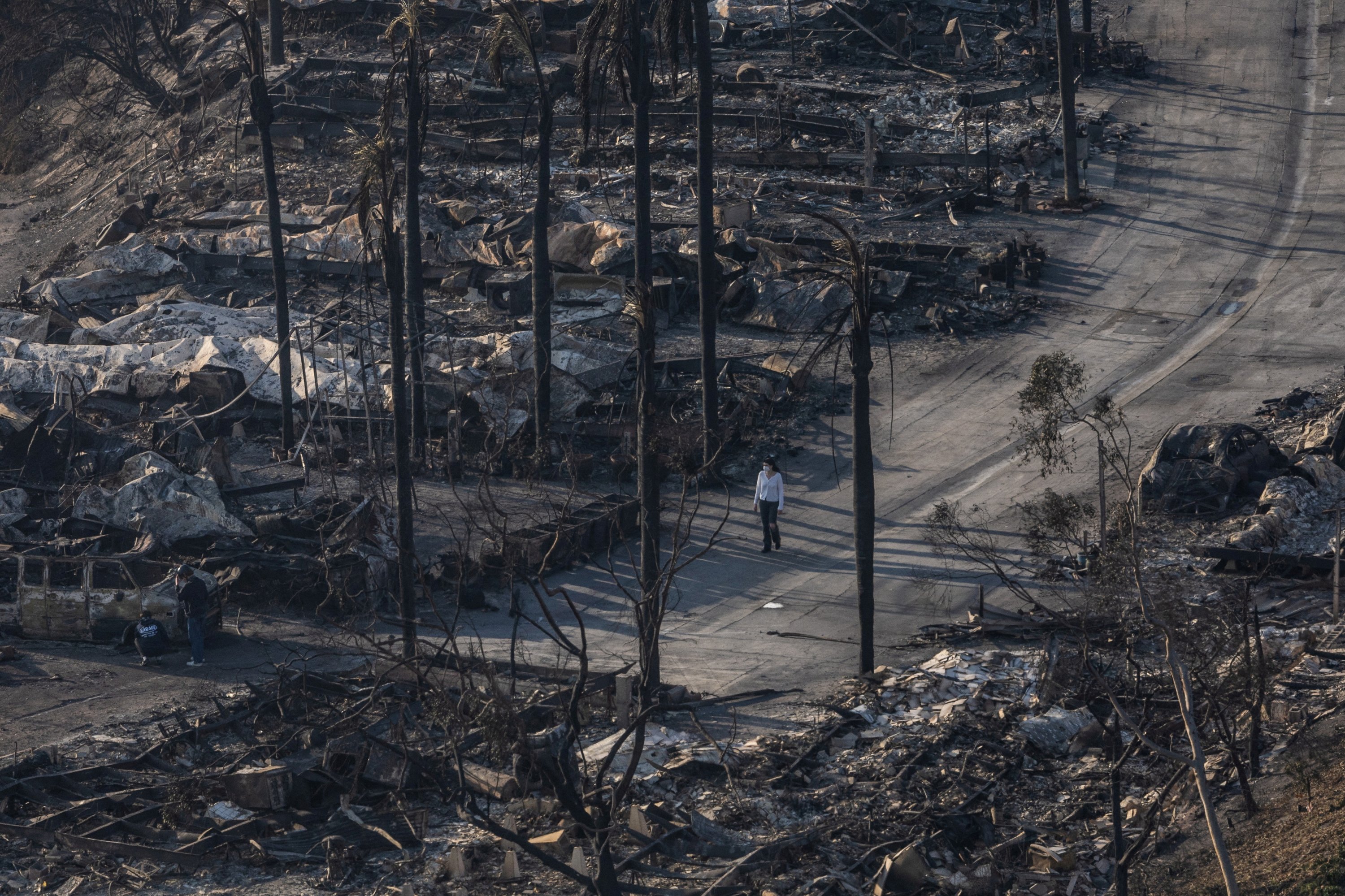 A woman walks past the remains of homes destroyed by the Palisades Fire in the Pacific Palisades neighborhood in Los Angeles, California, U.S., Jan. 11, 2025. (Reuters Photo)