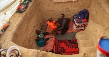 Palestinian father Tayseer Obaid, who was displaced with his family from the northern Gaza Strip, sits with his children in a trench he dug at a makeshift camp in Deir al-Balah, southern Gaza, Palestine, Jan. 8, 2025. (AFP Photo)
